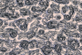Jos Scholte used a 3D-printer from industrial partner Dunlee to create a capillary porous structure out of tungsten: a sponge for liquid metal. This microscope image shows smooth, solidified flows of the metal lying on top of the 3D-printed (ridged) tungsten. Credit: Jos Scholte